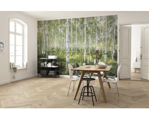 Ljust vardagsrum med fototapet av björkskog, matbord och trägolv
