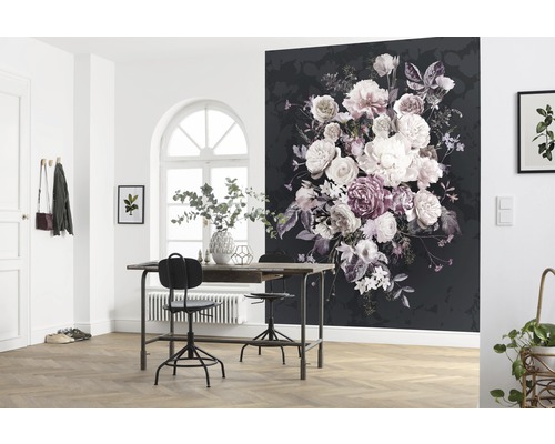 Dekorativt rum med en svart fototapet med blommönster, ett bord, stolar och växter