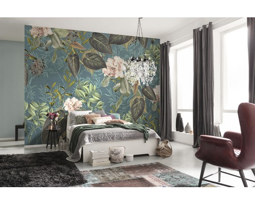 Sovrum med blommig tapet, säng, matta och fåtölj