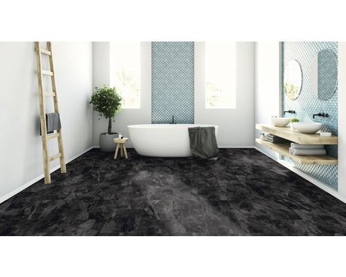 Modernt badrum med badkar, tvättställ och mörkt kakelgolv