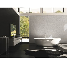 Badrum med badkar, handfat och stort fönster med utsikt över grönområde