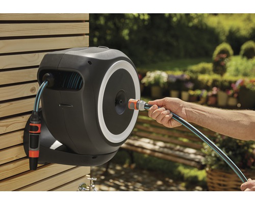 Vägmonterad trädgårdsslangbox med slanganslutning i handen