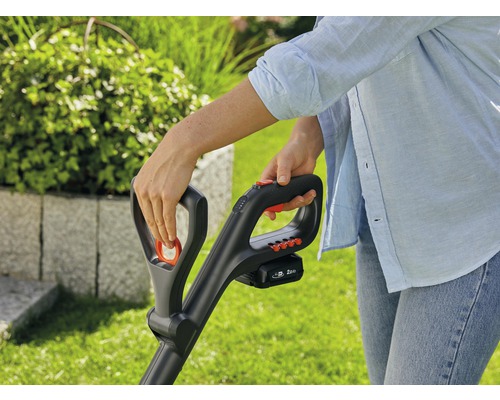 Närbild av en person som använder en batteridriven grästrimmer, tillgänglig i Hornbachs webbutik.