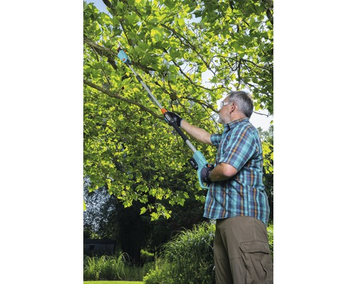 Man beskär grenar med en batteridriven grensax i trädgården