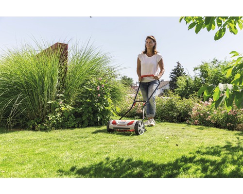 Kvinna använder handjagare i trädgården.