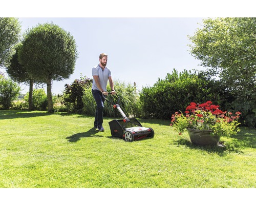 Man använder gräsmattluftare i trädgården.