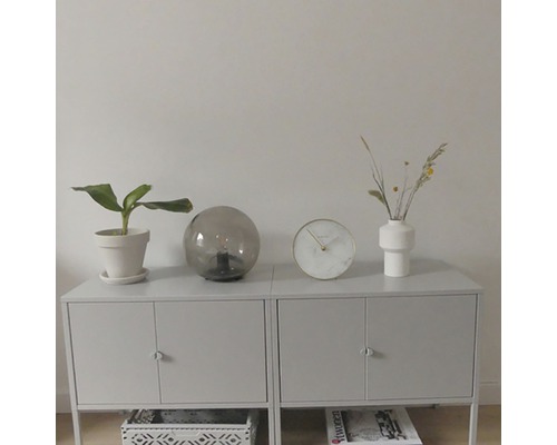 Skänk med krukväxt, bordslampa, klocka och vas
