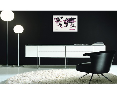 Interiör med två golvlampor, en skänk, en fåtölj och en världskarta på väggen.