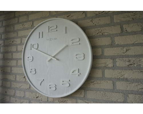 Nextime Logo Rund väggklocka på tegelvägg