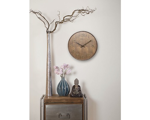 Vardagsrumsdekoration med en klocka, vaser och en Buddhafigur på ett sidobord