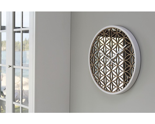 Rund väggklocka med blommönster på en vägg