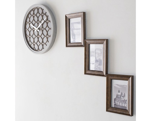 Väggklocka och tre fotoramar på väggen