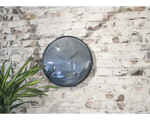 Nextime väggklocka på en tegelvägg