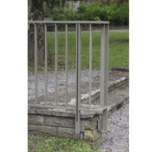 Närbild av ett metallräcke fäst vid en stenmur.