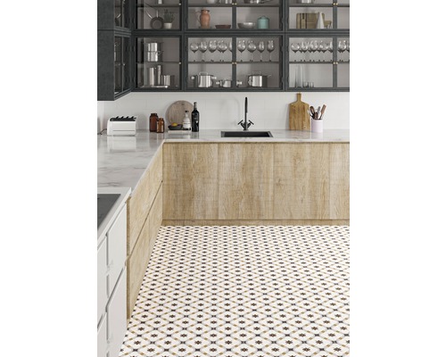 Ljust kök med mönstrat golvklinker, diskho och köksskåp