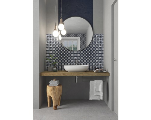 Ljust badrum med rund spegel, handfat och mosaikplattor