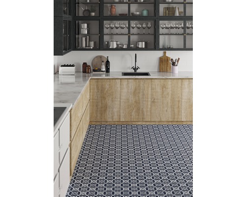 Köksscen med diskho, armatur, bänkskiva och mönstrade golvplattor.