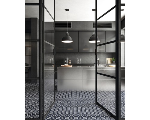 Modernt kök med köksö, hänglampor och mönstrat golv sett genom en glasdörr.