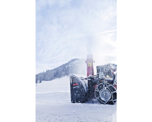 Snöslunga i arbete framför ett snötäckt landskap