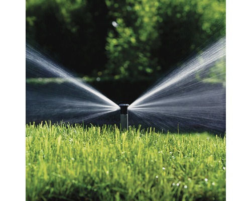 Bevattningssystem sprinkler i drift på gräsmatta