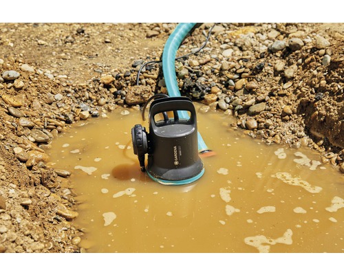 Gardena smutsvattenpump i ett hål fyllt med smutsigt vatten