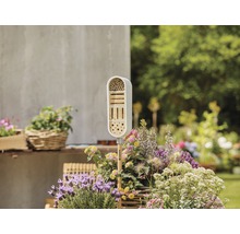 Insekthotell i trädgården, omgiven av blommor