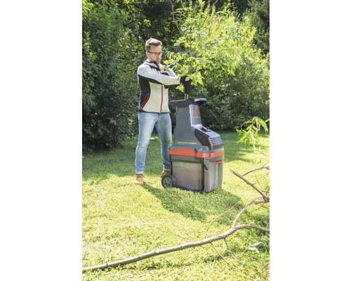 Man använder en trädgårdshackare i trädgården.