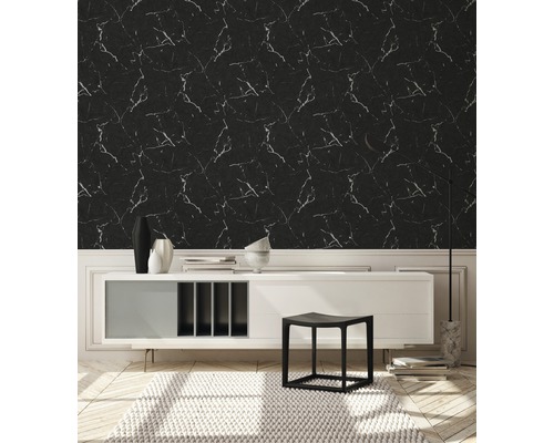 Ett rum med en vägg med marmortapet, en skänk och en matta.