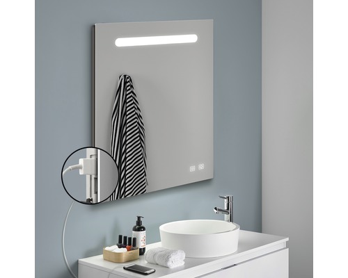 Badrum med belyst spegel, handfat och handduk