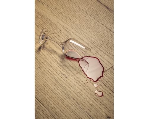 Vält vinglas på ett trägolv med spillt vin