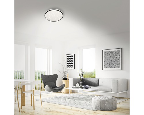 Ljust vardagsrum med taklampa, soffa och dekoration