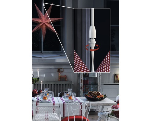 Festligt dukat matbord med upplyst fönsterstjärna och vred för att fästa stjärnan