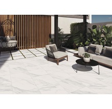 Terrass med golvplattor i marmorlook, loungemöbler och dekorativa växter