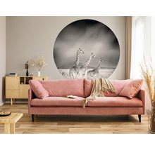Vardagsrum med rosa soffa, träbord och väggdekor med giraffmotiv