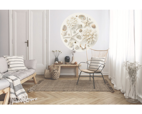 Vardagsrum med soffa, fåtölj, matta, bord och väggdekal med snäckor
