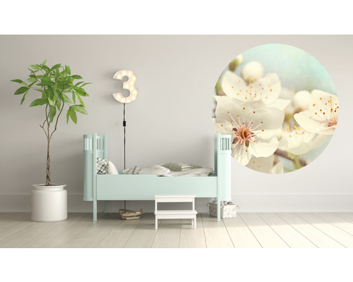 Ljust barnrum med säng, växt, upplyst siffra tre och cirkelformat blomfoto på väggen