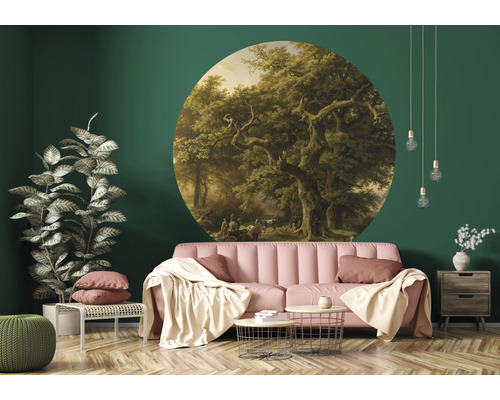 Dekorativt vardagsrum med väggklistermärke av ett skogsparti, soffa och krukväxter.