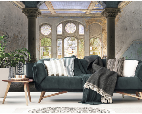 Vardagsrum med soffa, kuddar, filt, bord och väggmålning med fönstervy