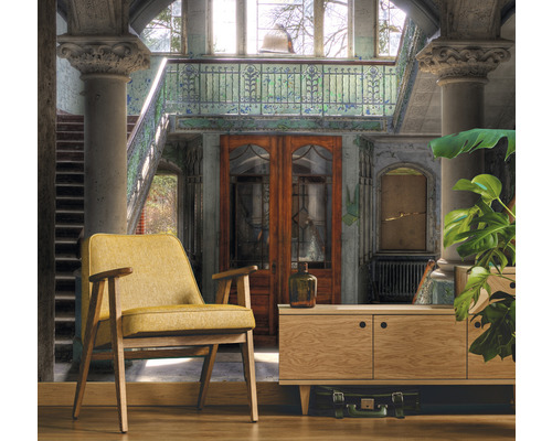 Interiörbild av ett rum med fåtölj, byrå och trappa