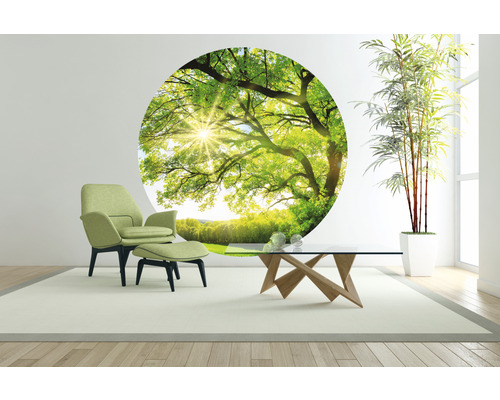 Ljust vardagsrum med fåtölj, bord och väggdekor med trädmotiv