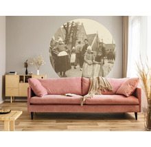 Modernt vardagsrum med rosa soffa, träskåp och väggmålning med bymotiv