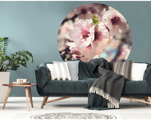 Vardagsrum med soffa, soffbord, krukväxt och väggdekor med blommönster