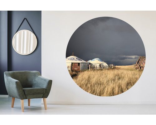 Dekorativt vardagsrum med fåtölj, spegel och väggmålning med landskapstema