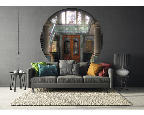 Vardagsrum med soffa, matta, bord och väggmålning med byggnadsvy