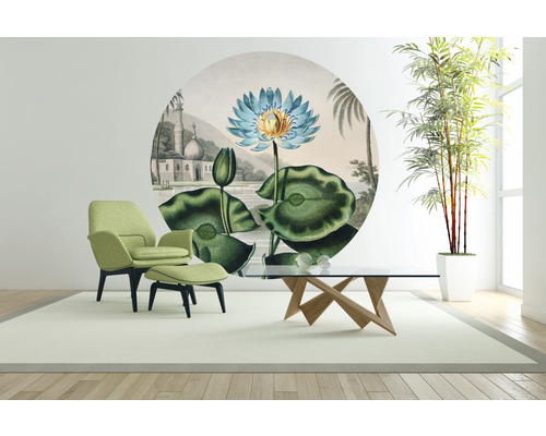 Vardagsrum med fåtölj, fotpall, bord, krukväxt och väggmålning med näckrosmotiv