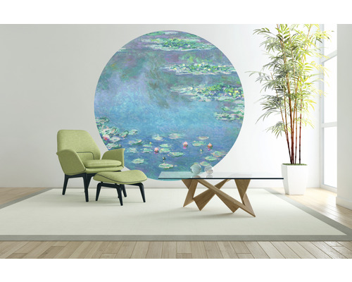 Vardagsrum med fåtöljer, soffbord, krukväxt och väggmålning