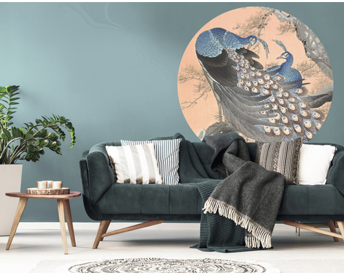 Vardagsrum med en soffa och en väggdekal med ett påfågelmotiv