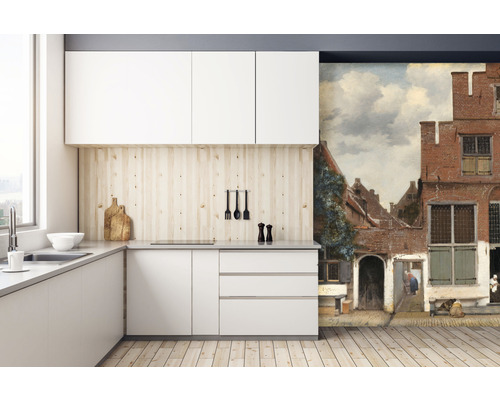 Modernt kök med vita skåp, träbänkskiva och väggmålning