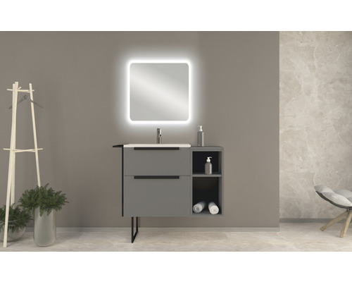 Modernt badrum med tvättställsskåp, belyst spegel och dekorationer för en stilfull atmosfär