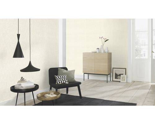 Vardagsrum med mönstrad tapet, sittmöbler, bord och hänglampor